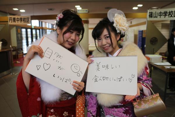 「自然がいっぱい」「美味しい食べ物いっぱい」と書いたが持って写っている、振袖を着た新成人2名の写真