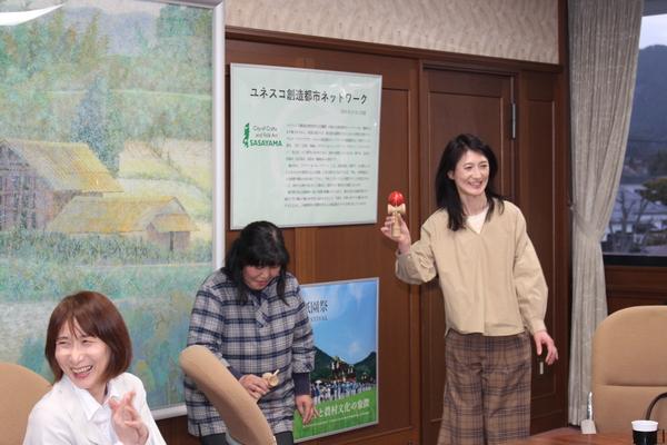 女性2名がけん玉を披露し、その横で笑っている女性の写真