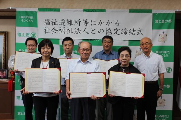 市長の横で、調印書を広げて持つ、男女6名の写真