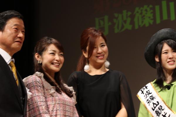 司会者が観光大使の女性らと一緒に笑顔で写っている写真