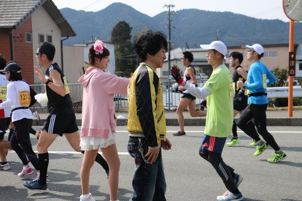 沿道で吉元芸人のかつみ、さゆりさん達がランナー達にハイタッチしながら応援している写真