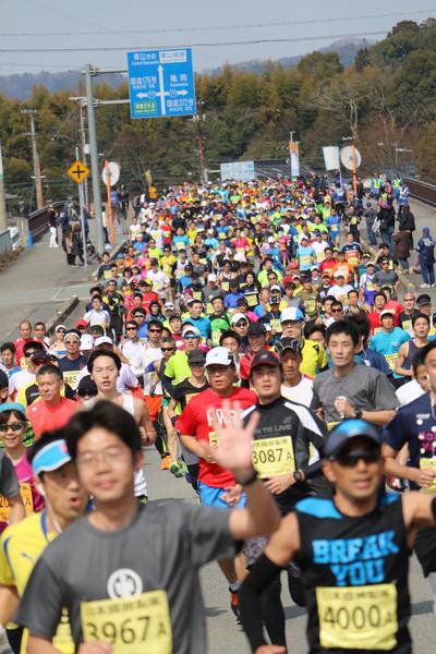 マラソンコースを参加者のランナー達がぎっしりと埋め尽くして走っている写真