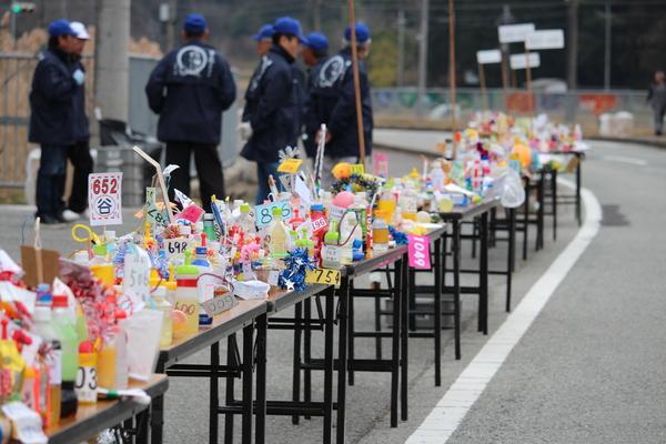 沿道では長机の上にカラフルな飾りのペットボトルが沢山置いている写真