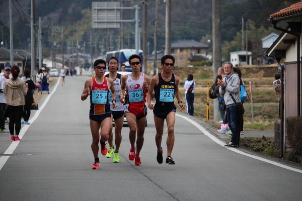 サングラスをかけた水色のゼッケンの4人の選手が競い合って走っている写真