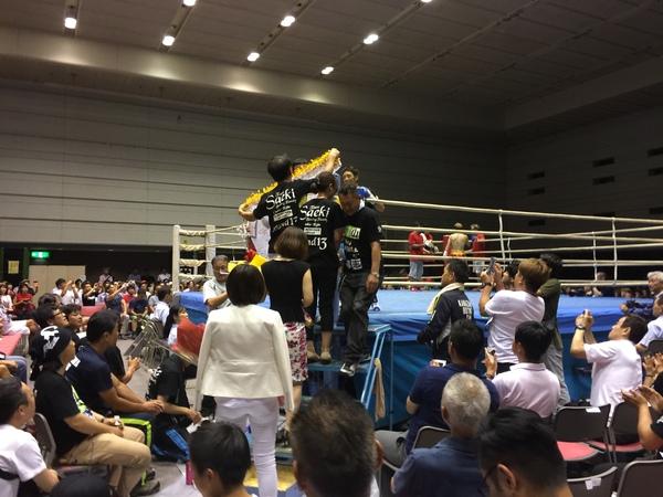リング上から下りてくる角谷選手を携帯などで撮影している方々の写真