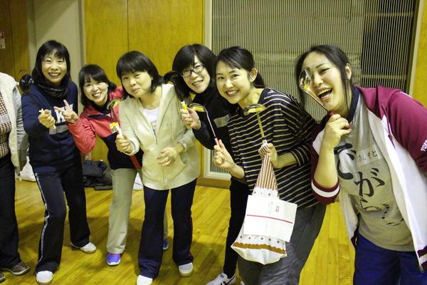 女性6名がお玉を持っており、右側にいる女性がお玉を目に当てて、笑顔で写っている写真