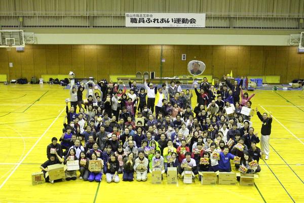 「職員ふれあい運動会」の横断幕が掛けられており、その前に参加した職員が集まって写っている集合写真