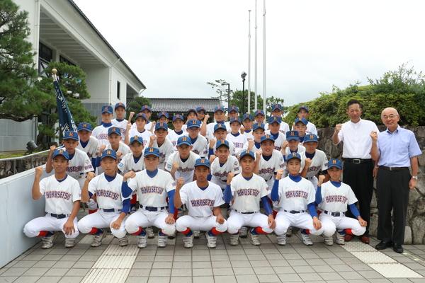 野球部員と市長と男性が、ガッツポーズをしている集合写真