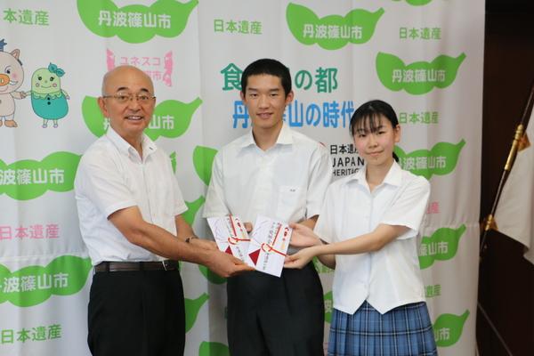 市長と中野一喜さん、小林優希さんが目録を手に持ち記念撮影写真