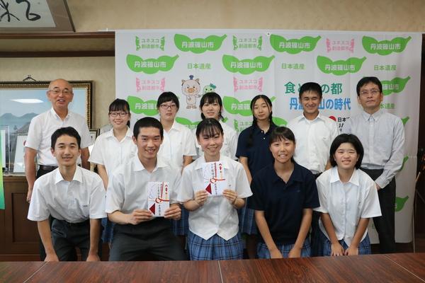 中野一喜さん、小林優希さんが目録を手に持ち部員のメンバーと市長と笑顔で記念撮影写真