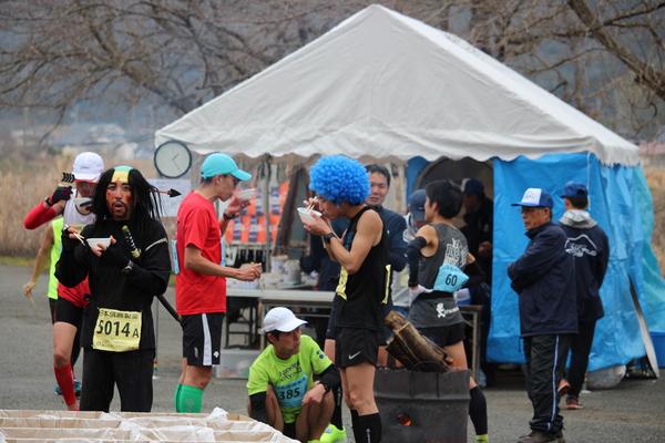 青色のアフロを被ったランナーや殿様の被り物をしたランナーの方が出された「しし汁」を美味しそうに食べている写真