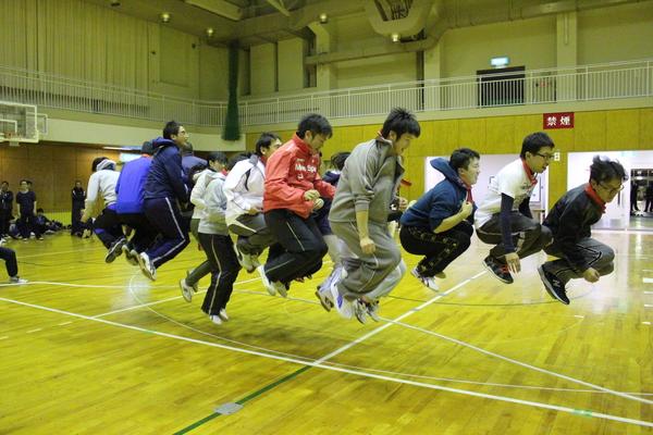大縄跳びで、カエルの様に飛んでいる職員方の写真
