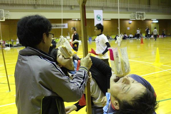 パン食い競争で2人が食いついてパンをゲットしようとする写真