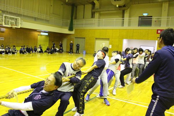 倒れそうになるくらいに綱を引いて争う写真