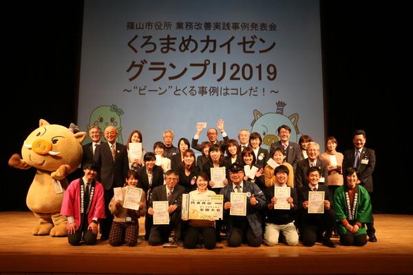 「くろまめカイゼングランプリ2019」で表彰された方皆で記念撮影をしている写真