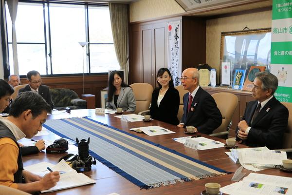 市長が発言していて、メモを取っている人や話を聞いている様子の写真