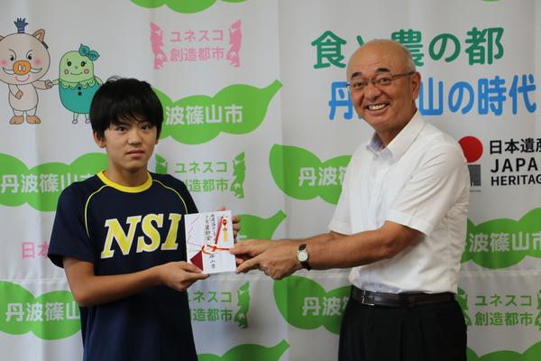 市長からのし袋を受け取る小稲君の写真