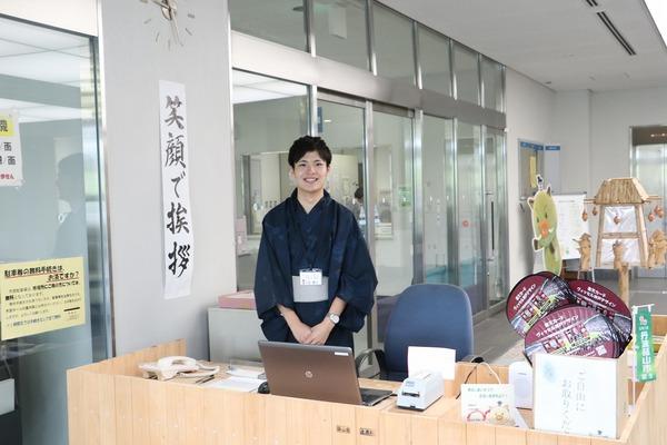 涼しげな浴衣姿の男性職員が笑顔で窓口に立っている写真