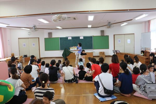 親子で絵本の読み聞かせを聞いている写真