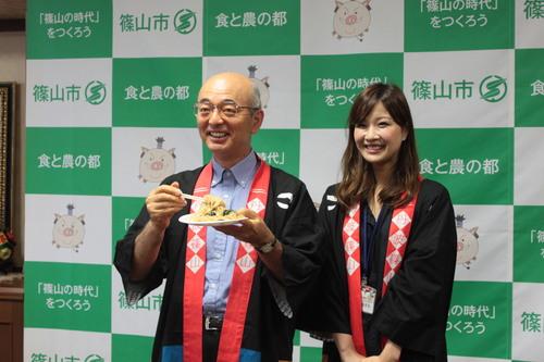 市長が女性と黒豆ビーフンをPRしている写真