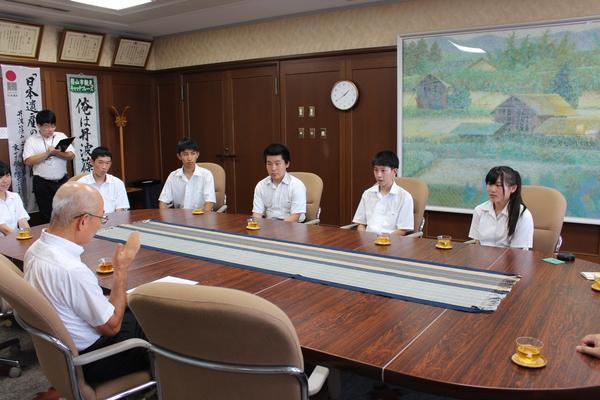 応接室にて、座って市長と話をしている男女の高校生の写真