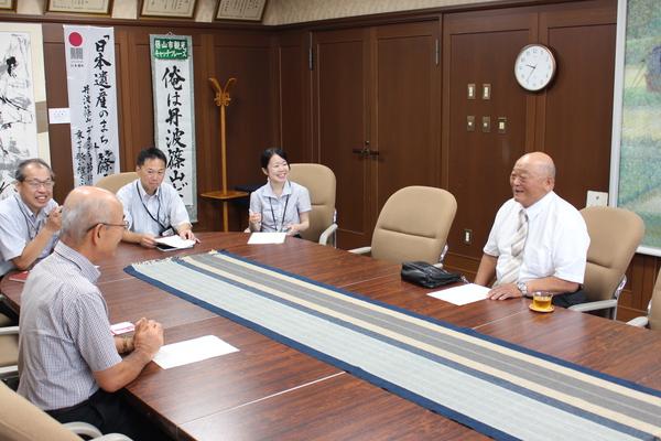 応接室に着席する、井関 道夫さんと市長、関係者の写真