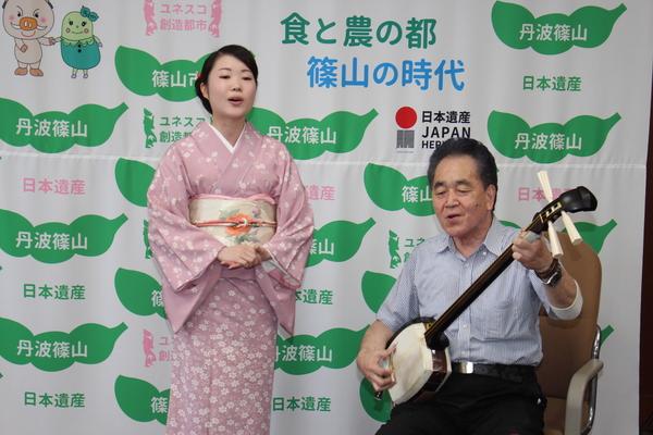 座って三味線を弾く山口先生とその横に立って民謡を歌う小林さんの写真