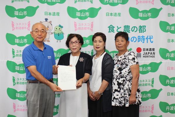 市長と農村女性組織連絡会の方が市名変更の要望書を一緒に持って写っている写真