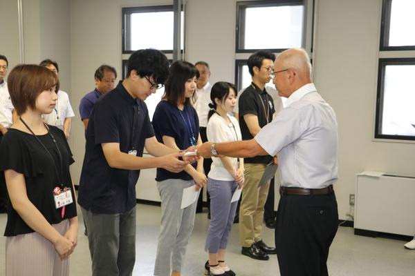 男性職員が、市長より何かを受け取っている写真