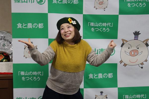 森田 まりこさんが右手を横に広げ、左手は拳をにぎり、お茶目な表情で写っている写真