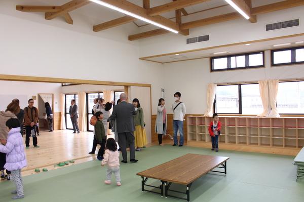 畳と、フローリングの室内で、たくさんの老若男女が写真を撮ったり、あたりを見渡している写真