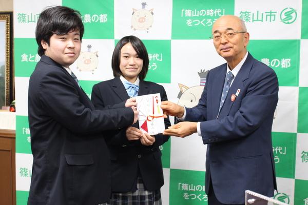 「エコワングランプリ」に出場する2名の学生に市長より目録が渡されている写真