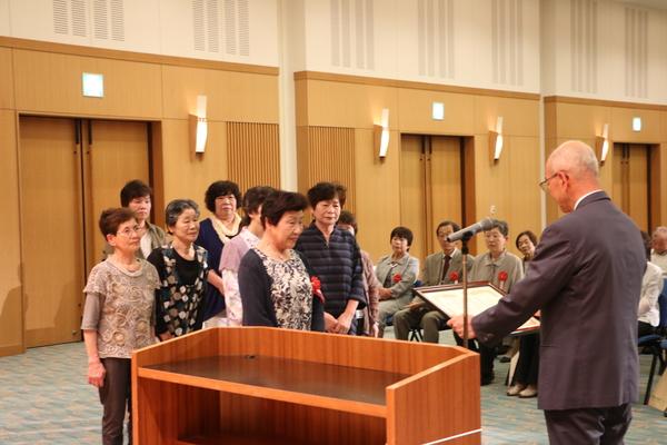 8人の女性グループに賞状を読み上げている市長の写真