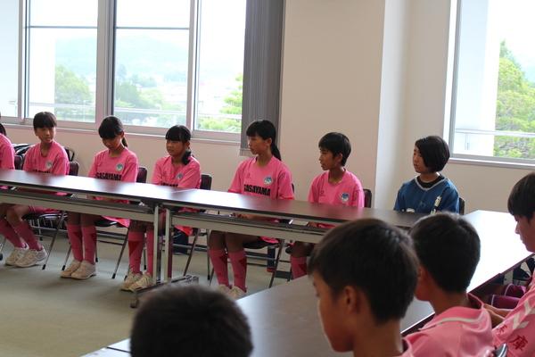 長机に座っているユニホーム姿のホッケー部中学生の写真