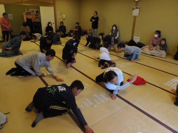かるたの札を弾いたり、構のポーズをとる参加者の写真