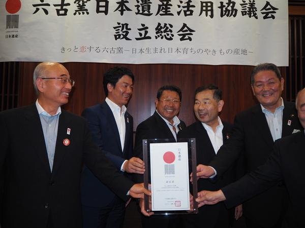 「六古窯日本遺産活用協議会 設立総会」の横断幕の前で、市長と関係者が「日本遺産認定証」の盾を持って嬉しそうに笑顔で写っている写真
