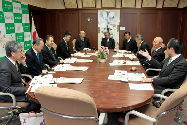 市長室のテーブルに 秋田県・大館鳳鳴高校の伊藤校長先生ら4人と関係者が座っており、会談している様子の写真