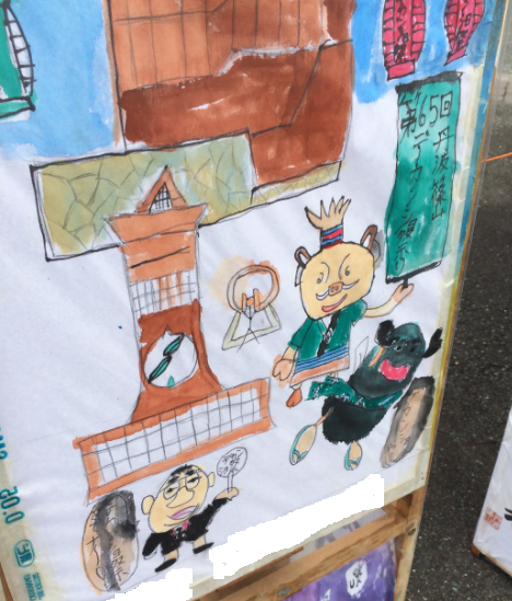 市長がうちわを手に持ち、豚さん達は看板を持っているポスター写真