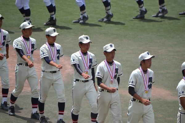 首にメダルをかけて部員全員で行進している写真