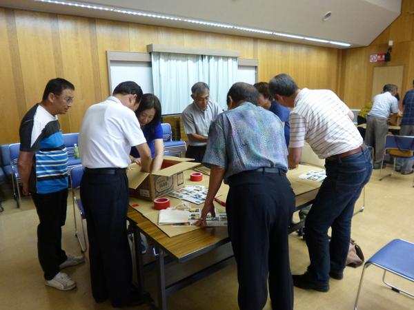 参加者が段ボールに手を入れて確認したり、意見を出したりしている写真