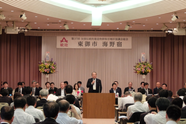 壁に東御市海野宿と書かれていて、その前の演題でマイクを持った男性が話をしている写真
