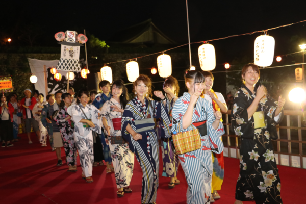 浴衣を着た参加者たちが楽しそうに踊っている写真