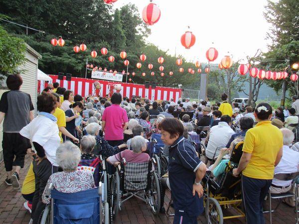 味間奥やすらぎ園祭のステージに太鼓が準備してあり、演奏を待っている車いすに乗った人々や施設職員らの写真