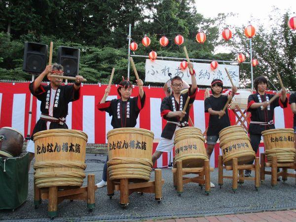 ステージでねじり鉢巻きに法被姿の男女らがたんなん桶太鼓をたたいている写真