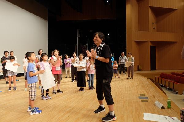 舞台で、指導者にレッスンを受けている様子の写真