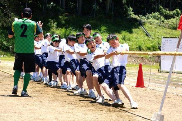綱引きで、緑のはちまきを頭に巻いた生徒たちが、一生懸命引っ張ている写真
