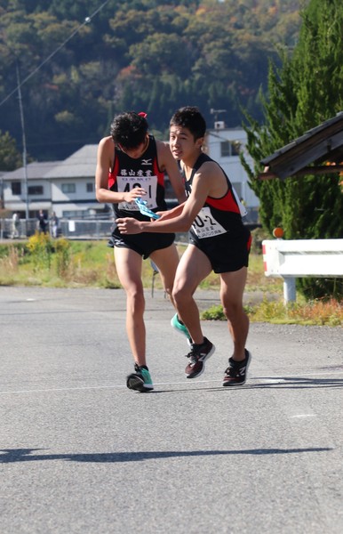 篠山産業高校生の一区村上君から二区吉田君へタスキをつないでいる瞬間の写真