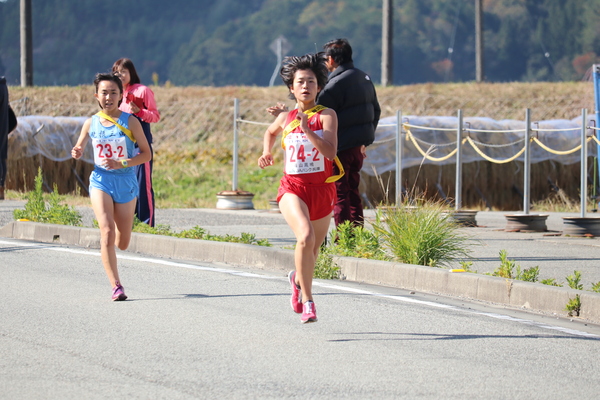 篠山鳳鳴高校二区坂元さんが走っている後ろから青いユニフォームのランナーが走っている写真