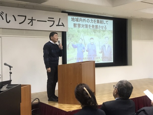 資料を投影したスクリーン横でマイクをもって話す中川さん