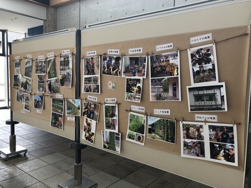 山の芋の手入れをする児童たちの写真がパネルに展示されている